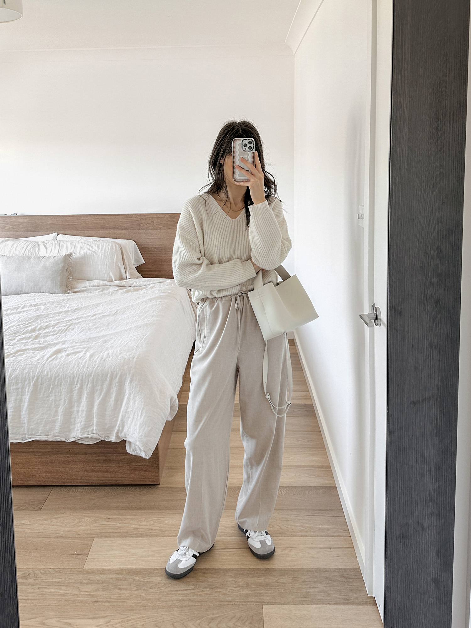 All neutral outfit with v neck sweater and beige trousers