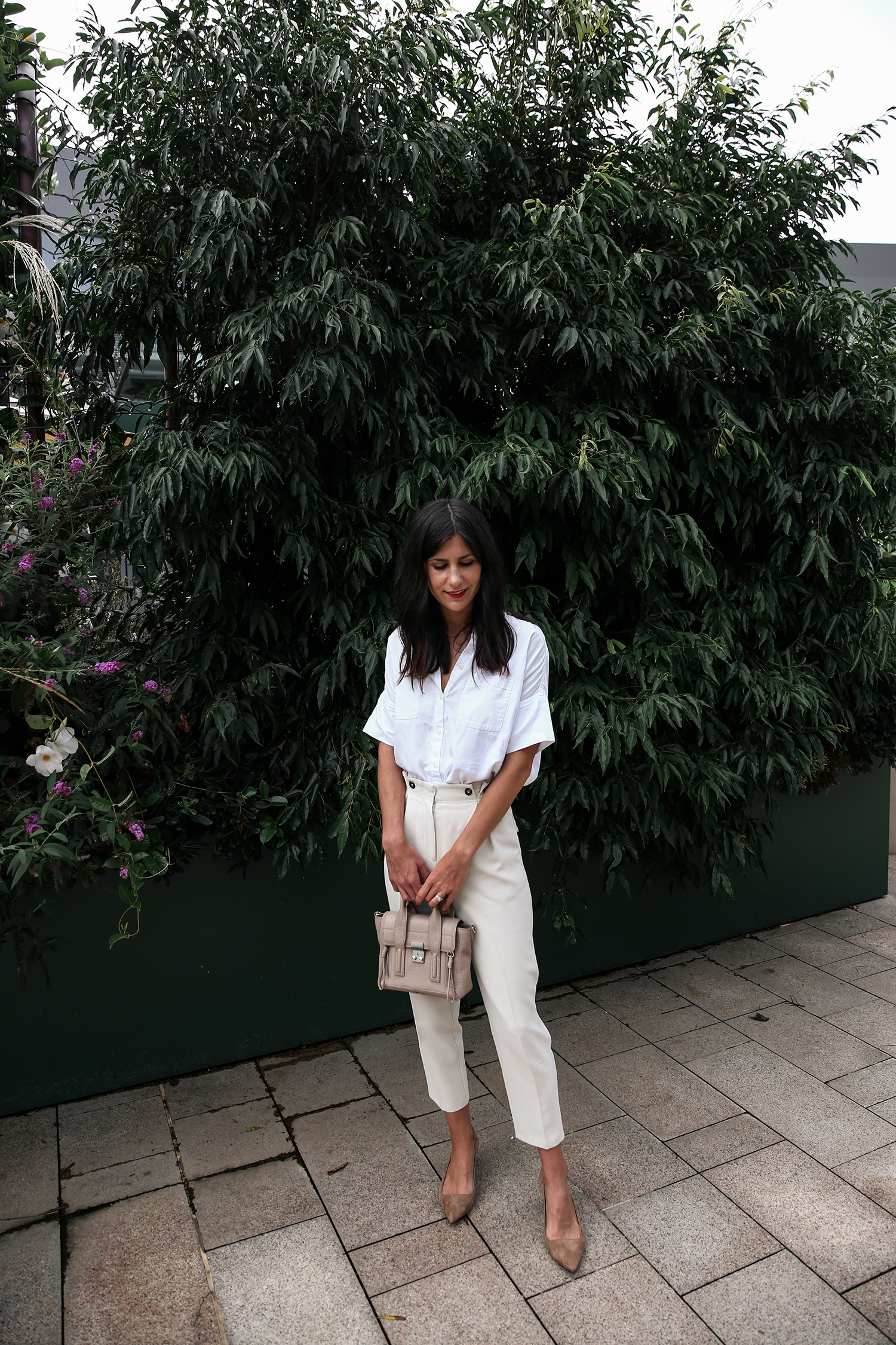 Wearing a neutral outfit with white shirt and beige trousers