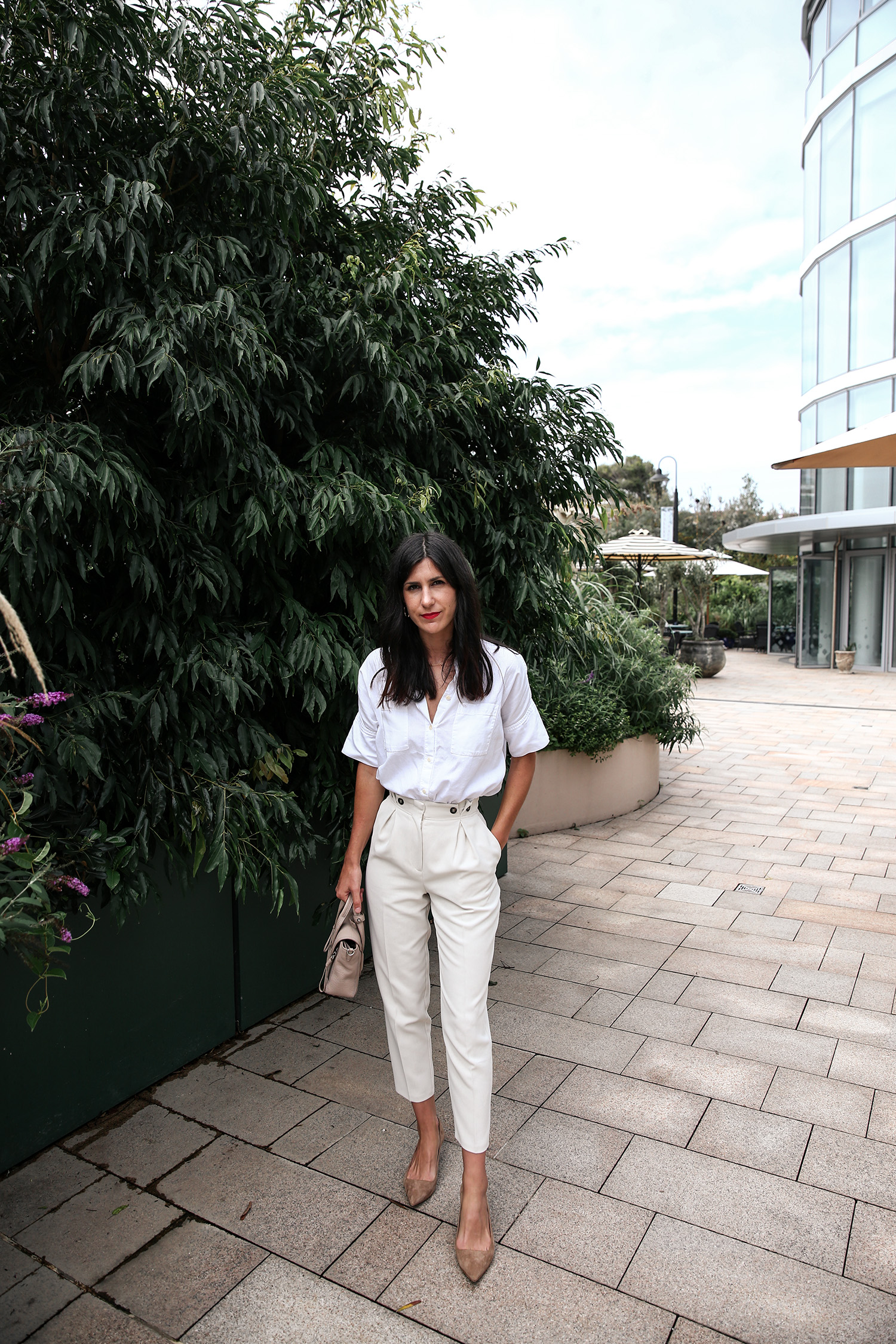 Wearing a neutral outfit with white shirt and beige trousers