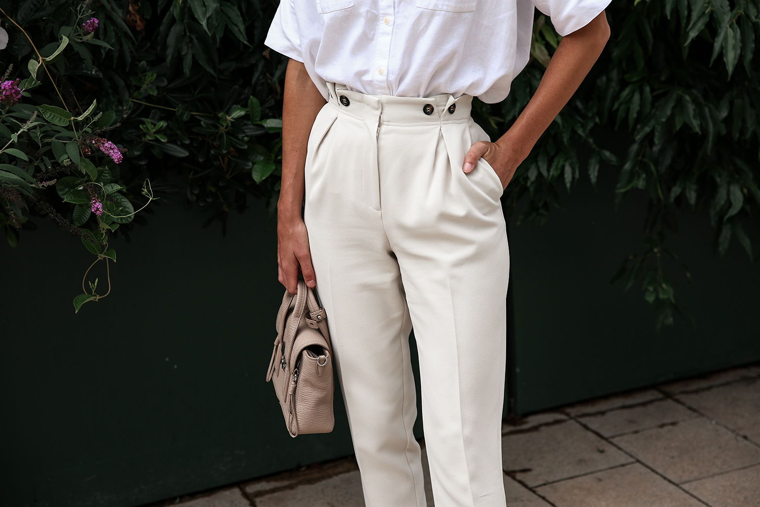 Wearing a neutral outfit with white shirt and beige trousers