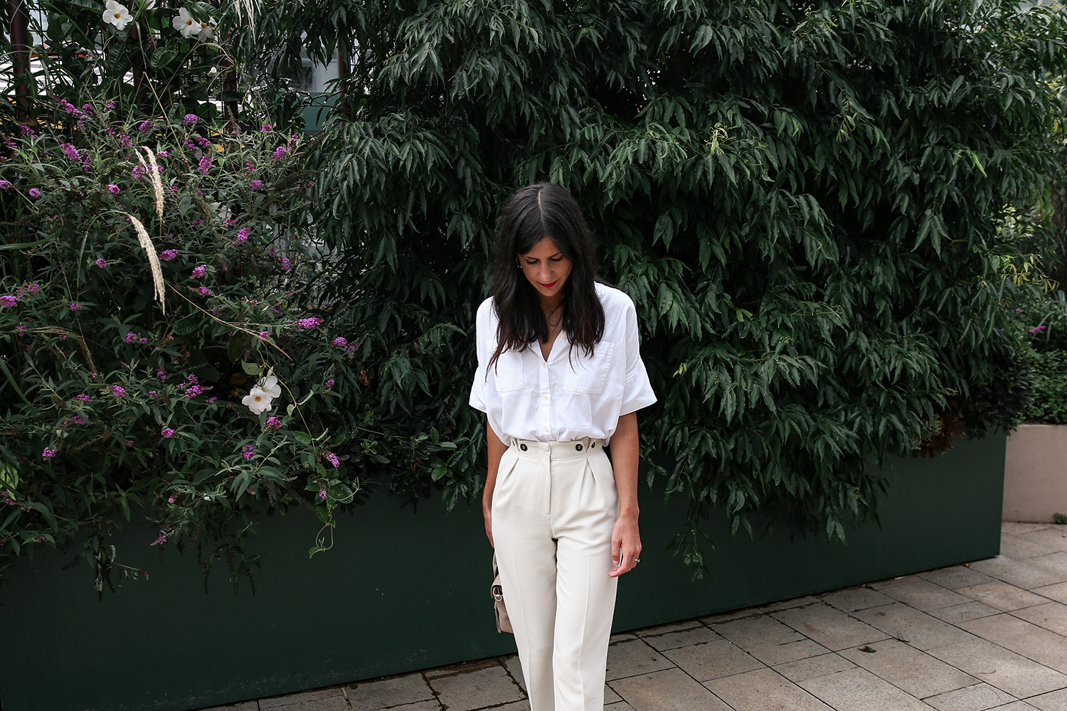 Wearing a neutral outfit with white shirt and beige trousers