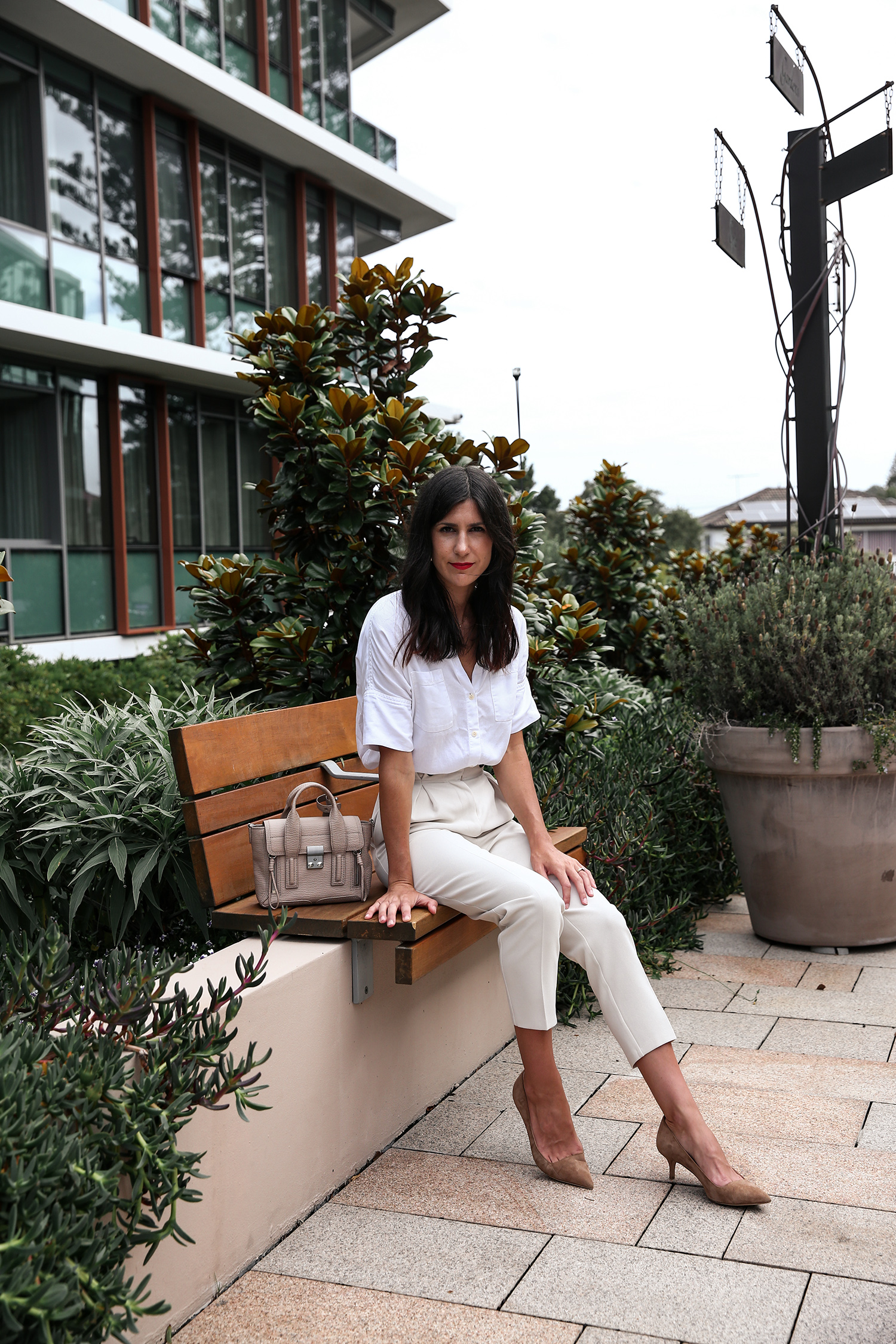 Wearing a neutral outfit with white shirt and beige trousers