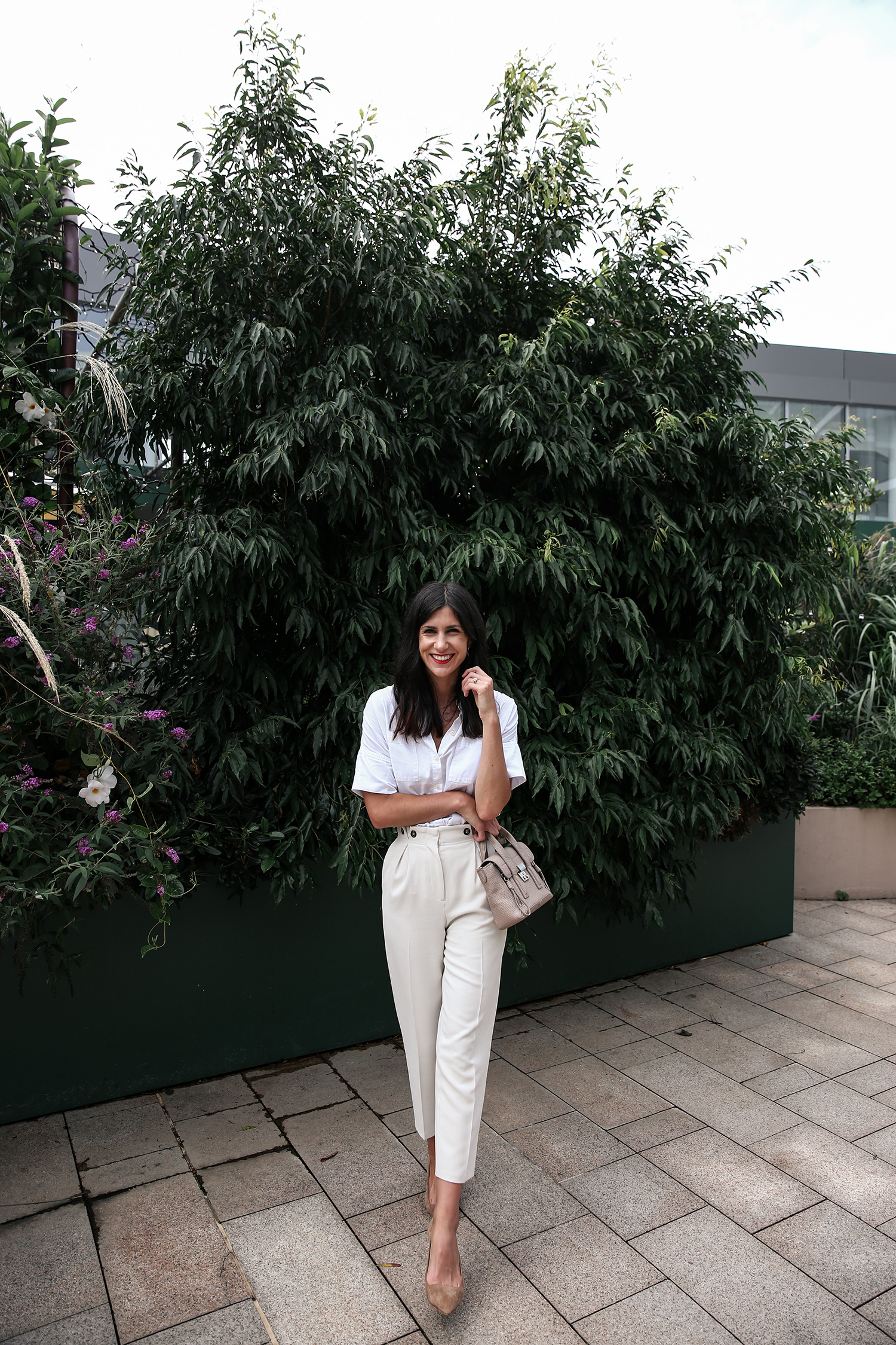 Wearing a neutral outfit with white shirt and beige trousers