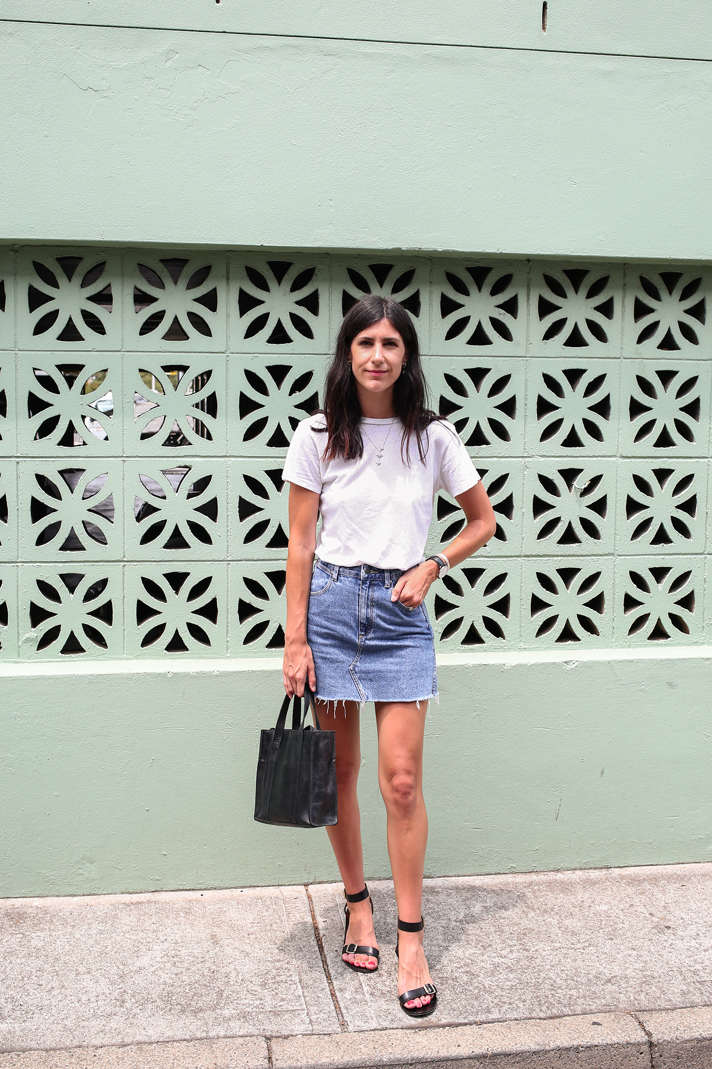 Friday Finds wearing a white tee and denim skirt