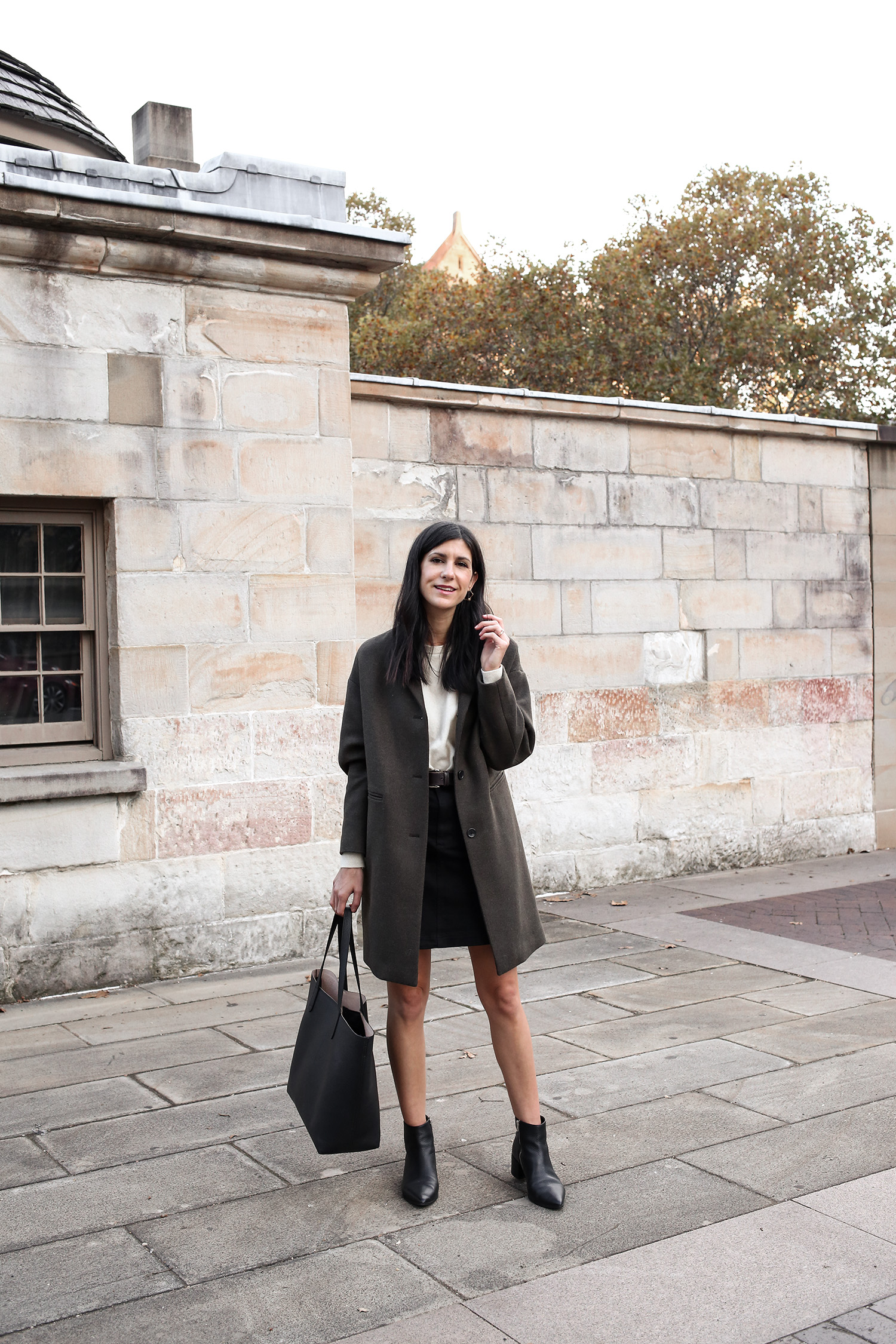 Jamie Lee Mademoiselle wearing an Autumn Minimal Style Outfit of a cashmere sweater with mini skirt and boots