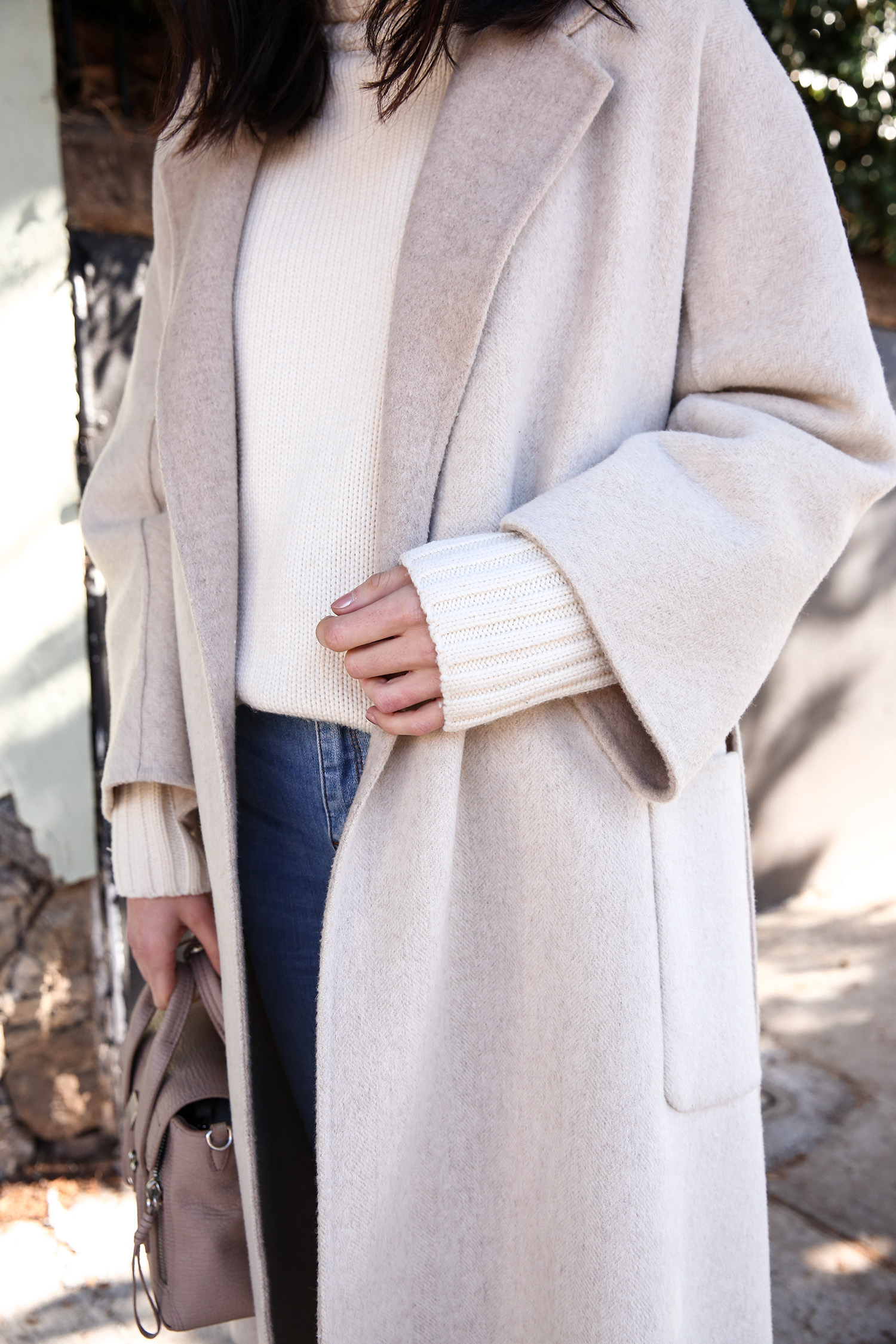 Scandi style outfit wearing white rollneck sweater skinny jeans and a duster coat