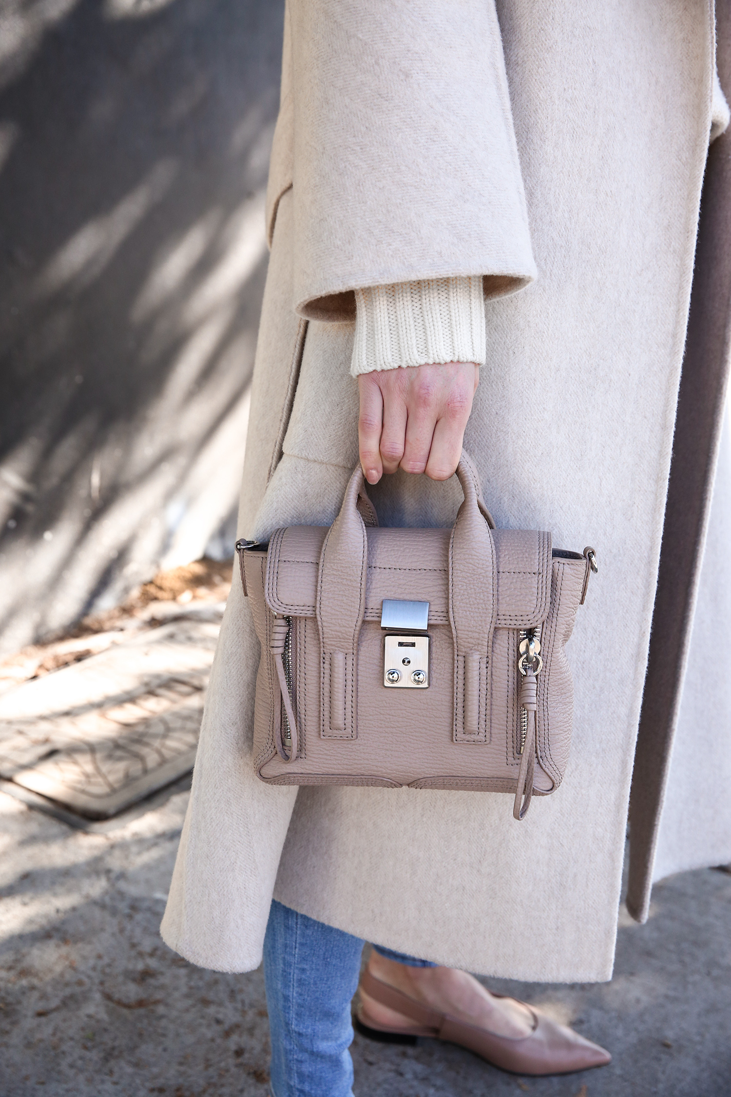 Scandi style outfit wearing white rollneck sweater skinny jeans and a duster coat