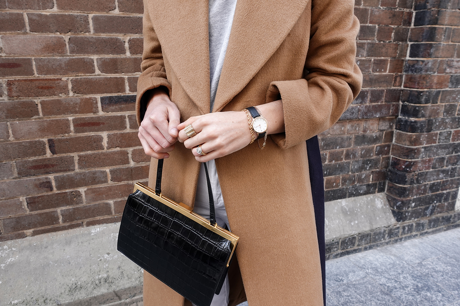 Neutral outfit in a minimal style wearing a camel coat and white jeans