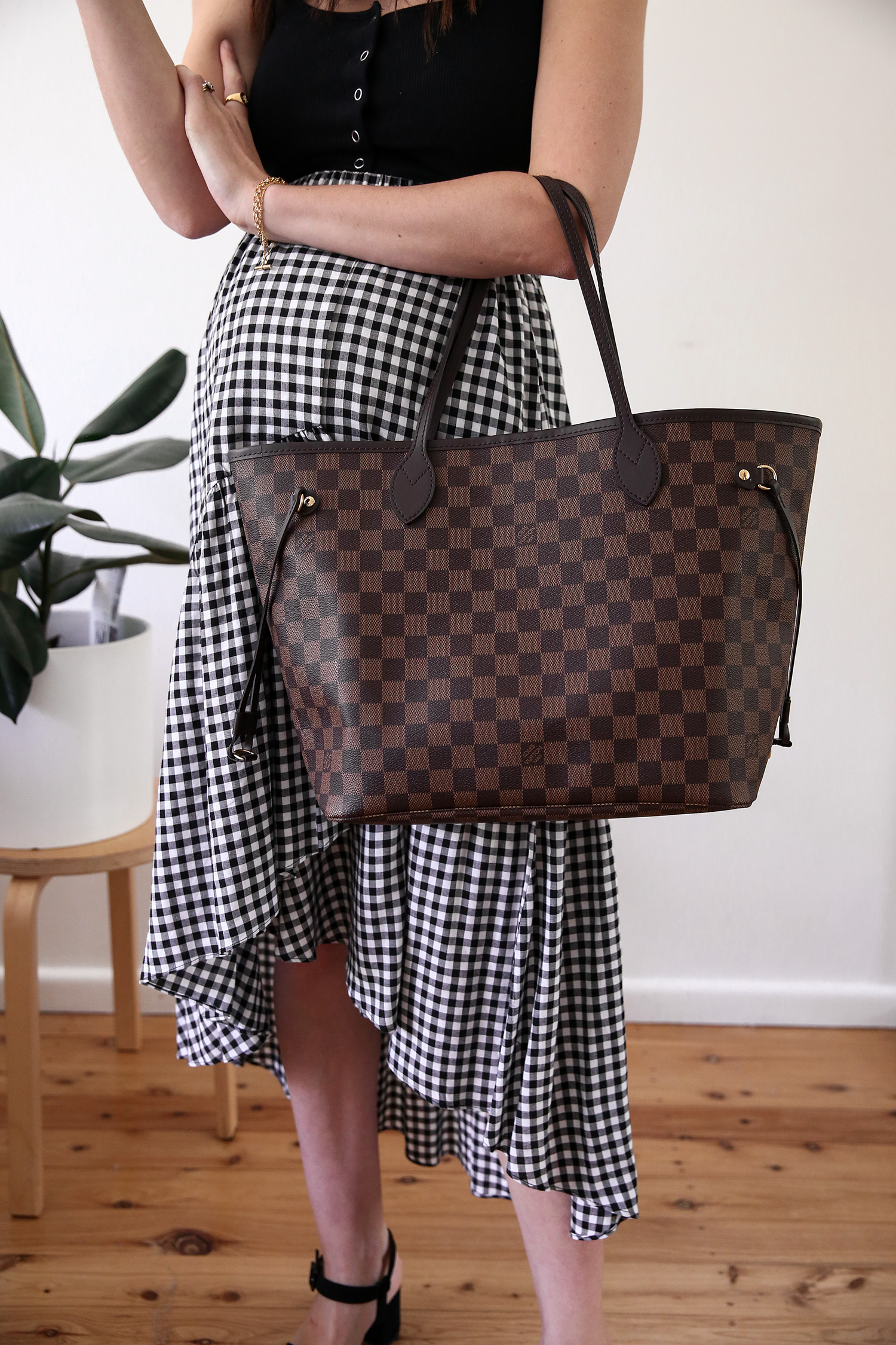 Maternity style wearing a black tank and gingham midi skirt