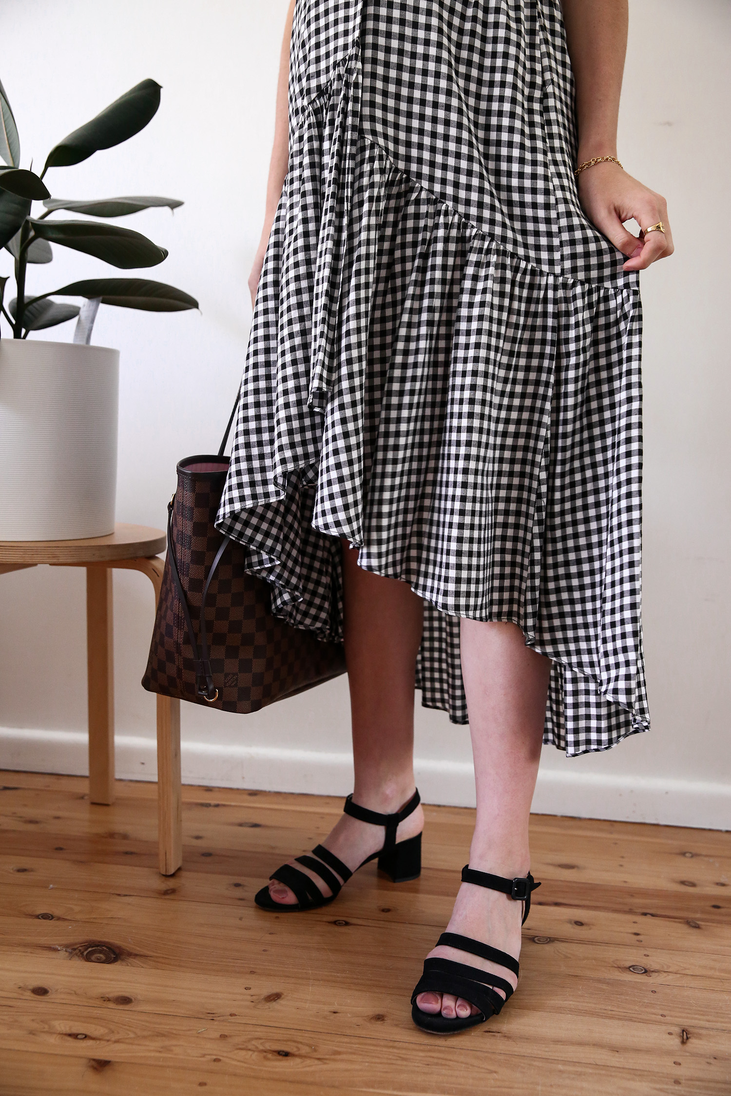 Maternity style wearing a black tank and gingham midi skirt
