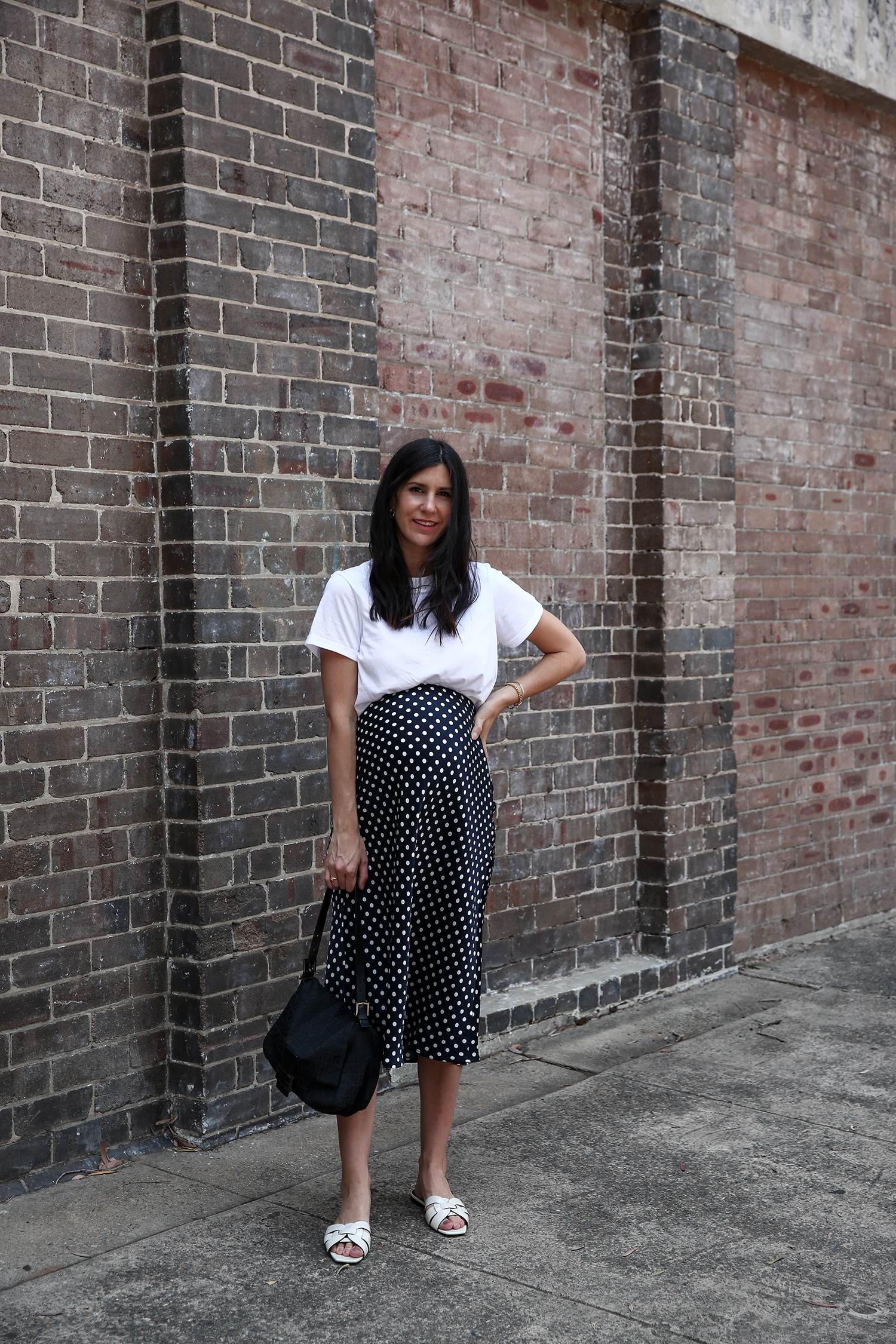 Jamie Lee of Mademoiselle wearing a white t shirt and polka dot midi skirt, minimal style, pregnancy style