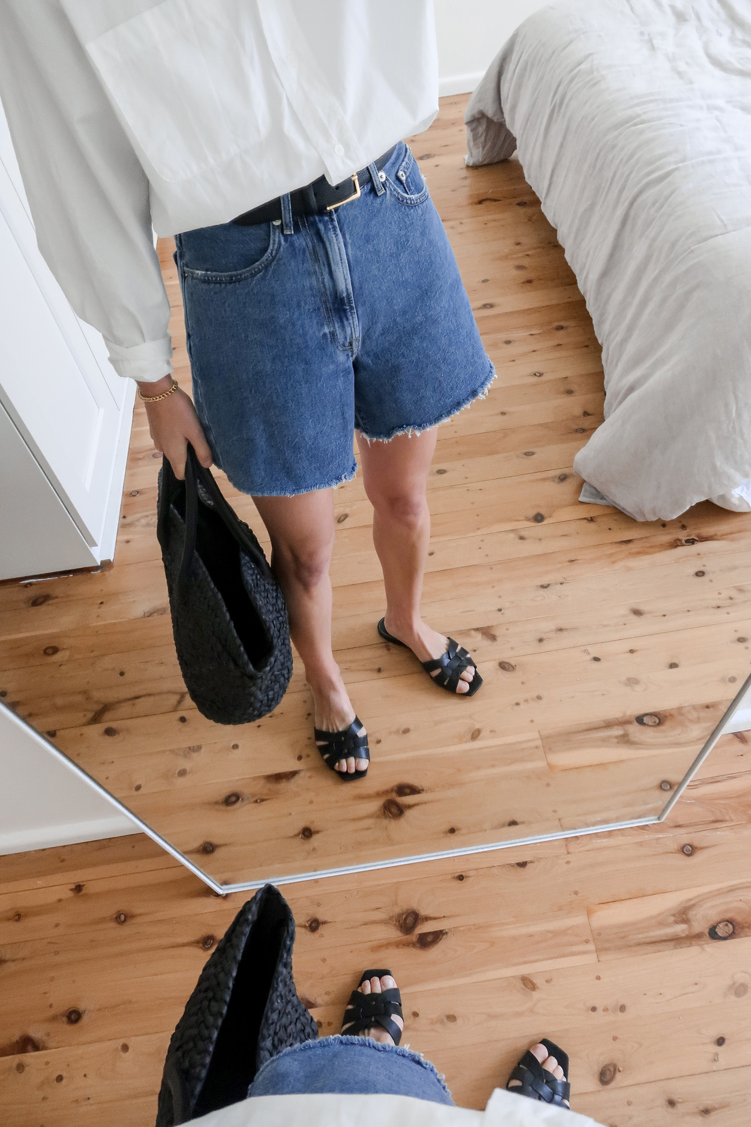 Minimal summer outfit idea wearing a white shirt and denim shorts