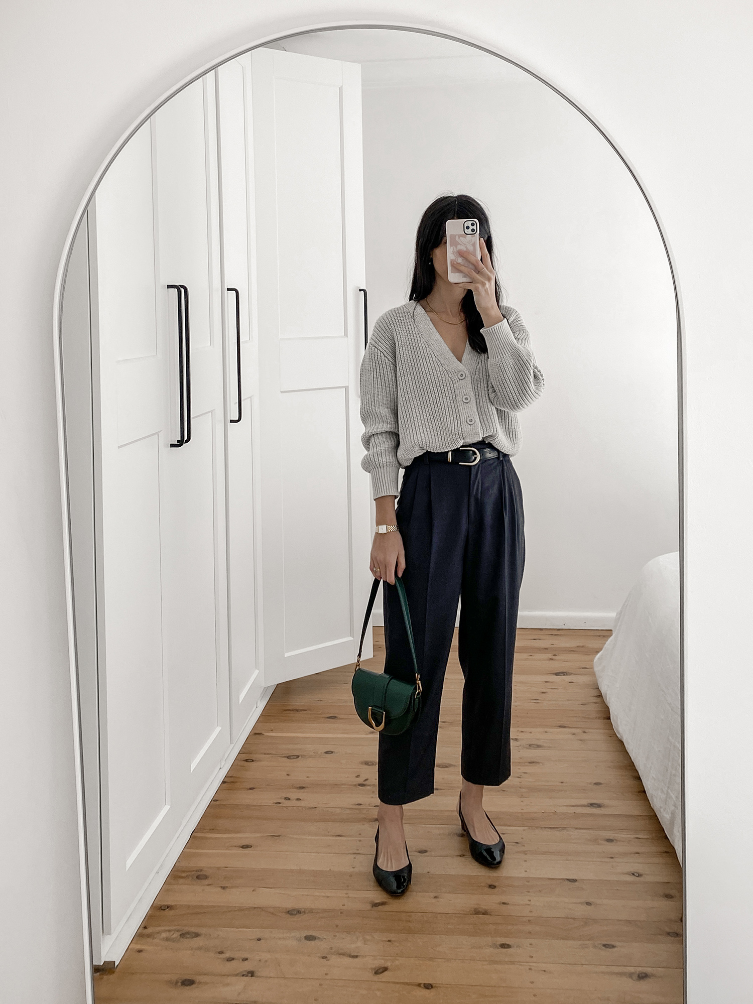 minimal style outfit wearing a grey cardigan tucked into straight leg pants