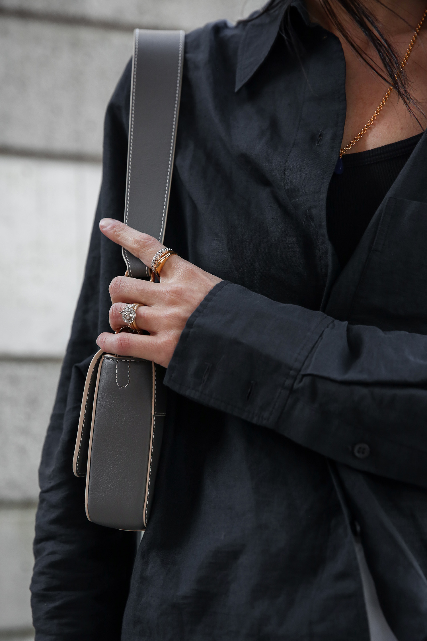 Minimal outfit wearing black linen shirt with white denim mini and grey shoulder bag