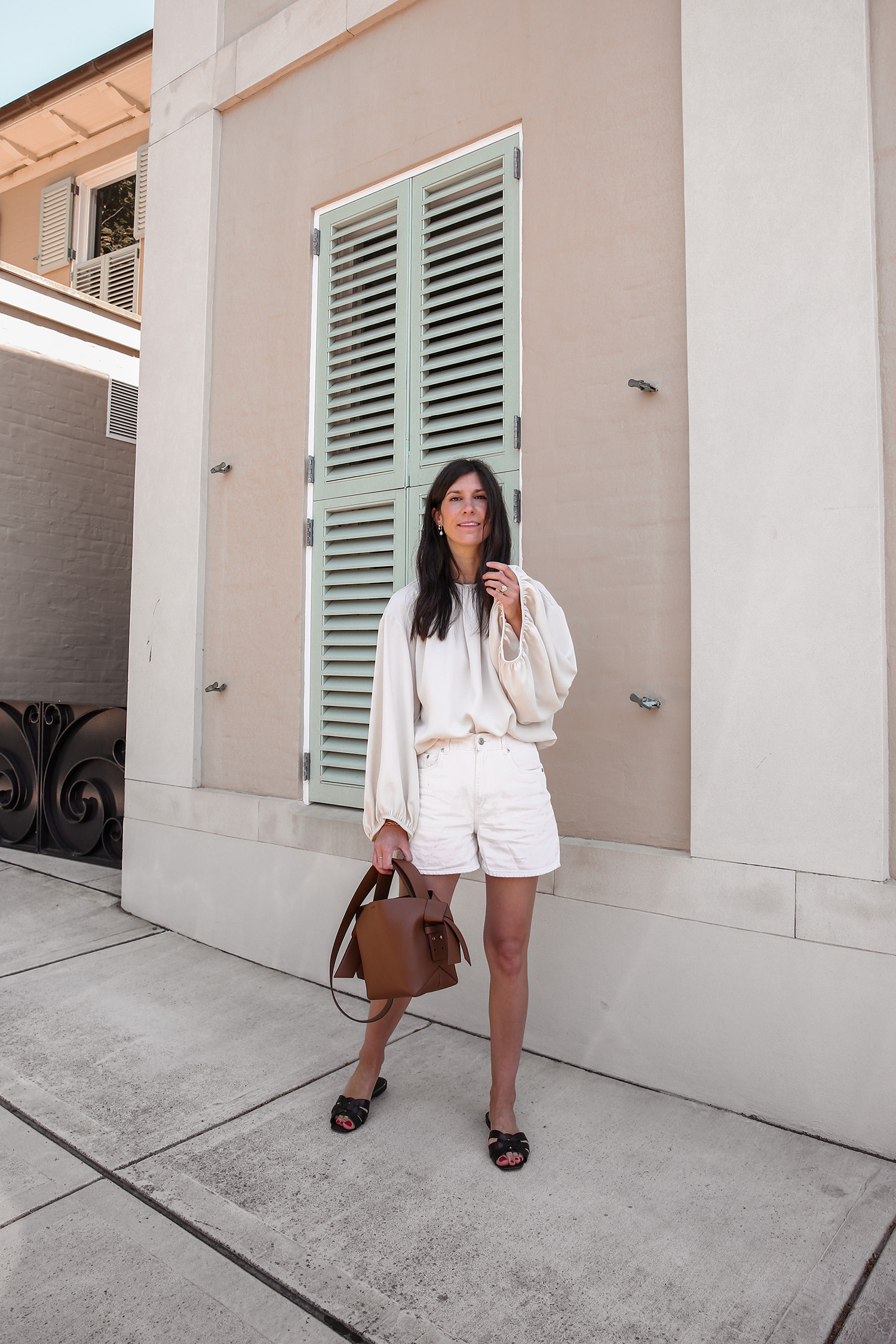 Minimalist neutral style outfit wearing Toteme top Arket shorts and Acne Mini Musubi bag in camel
