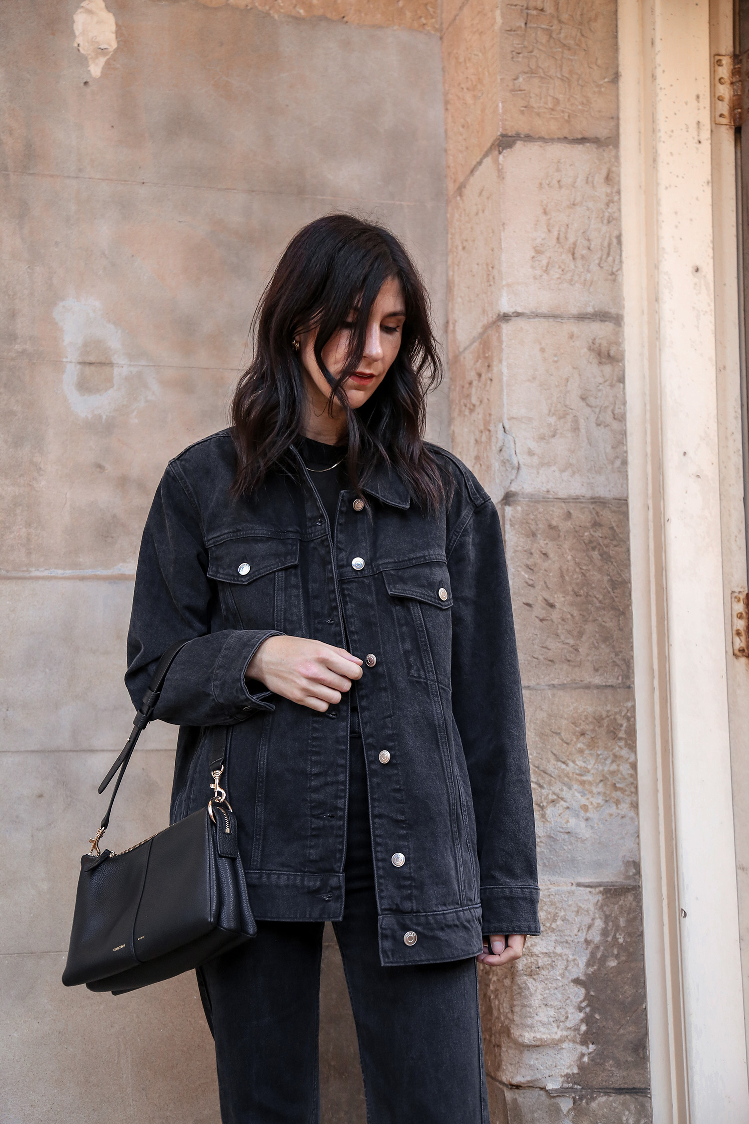All black outfit wearing Arket oversized denim jacket and Oroton Emma Small Day Bag