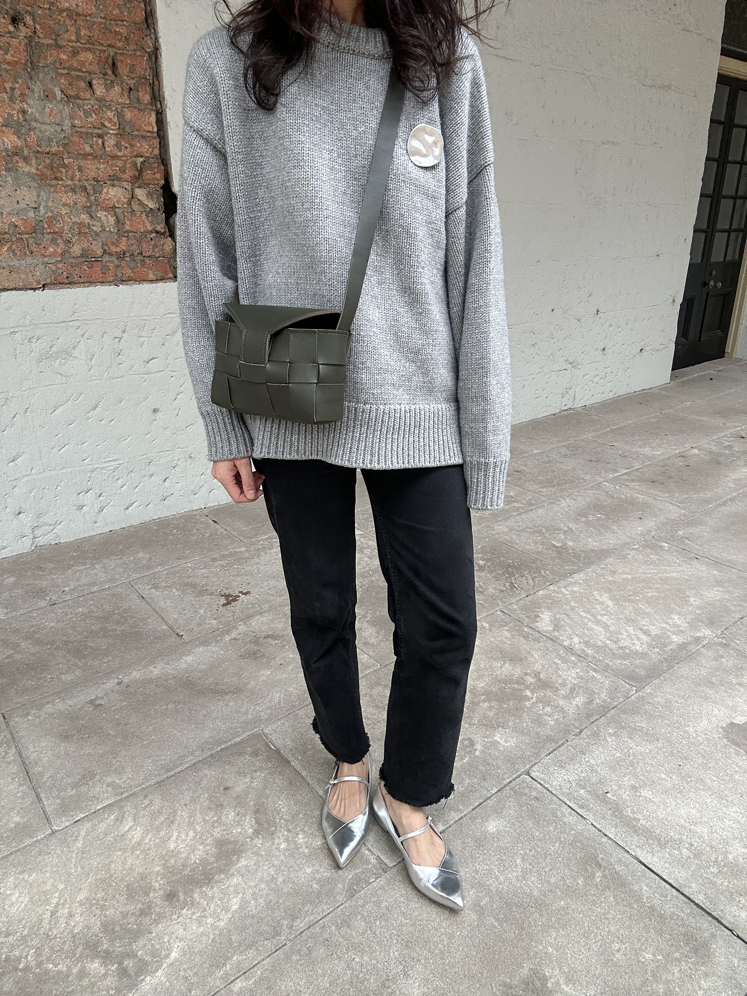 The Row Ophelia sweater styled with black jeans and silver Mary Jane flats